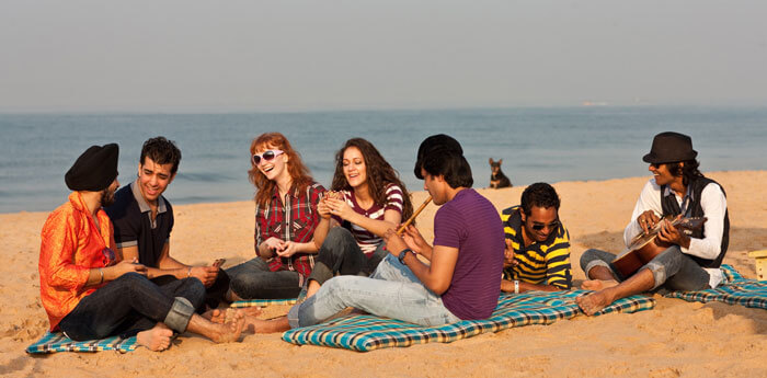 Friends relax and enjoy music at one the beaches at Goa